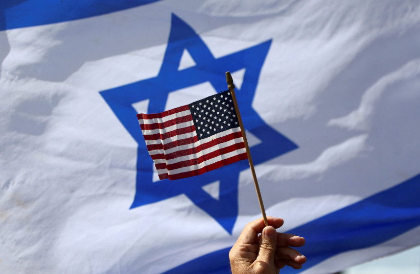  A view of a US flag and an Israeli flag held up by people during a demonstration to show support for U.S. President Joe Biden, for not inviting Israeli Prime Minister Benjamin Netanyahu to the White House, in front of the US Consulate in Tel Aviv, Israel, March 30, 2023.  (photo credit: REUTERS/Ronen Zvulun)
