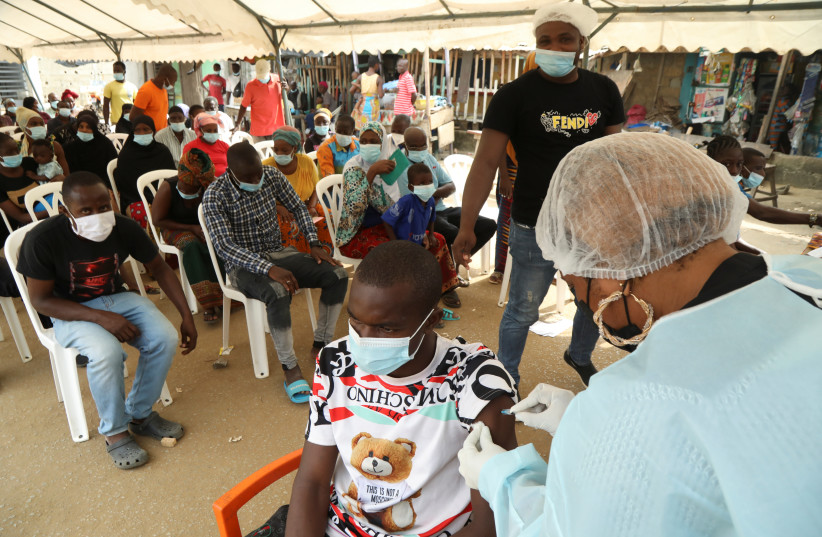  A resident receives a vaccine as the vaccinations against Ebola continue in Alakro, the slum where the first case of Ebola was confirmed, in Abidjan, Ivory Coast August 17, 2021 (photo credit: REUTERS/LUC GNAGO)
