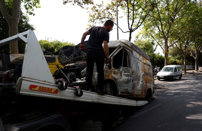  A car, burnt during clashes between youths and police, is removed from the street the day after the death of a 17-year-old teenager killed by a French police officer during a traffic stop, in Nanterre, Paris suburb, France, June 28, 2023 (photo credit: REUTERS)