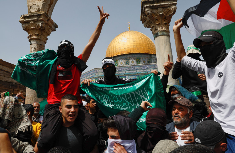  Palestinians demonstrate at Al-Aqsa Mosque as Palestinian Muslims attend Friday prayers of the Muslim holy month of Ramadan, on the compound known to Muslims as the Noble Sanctuary and to Jews as the Temple Mount, in Jerusalem's Old City, April 7, 2023. (photo credit: AMMAR AWAD/REUTERS)