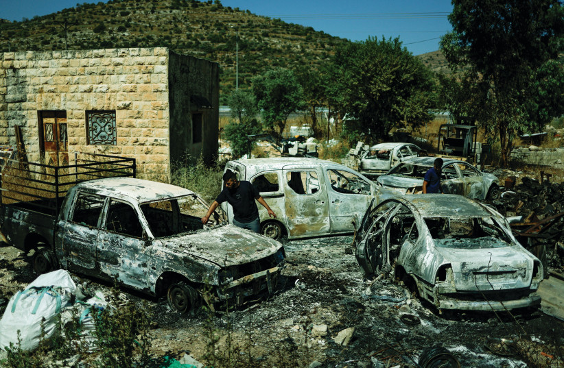  PALESTINIANS CHECK burned vehicles after a revenge attack by Jews in a village near Ramallah last week, following a murderous terrorist attack against settlers. (photo credit: AMMAR AWAD/REUTERS)