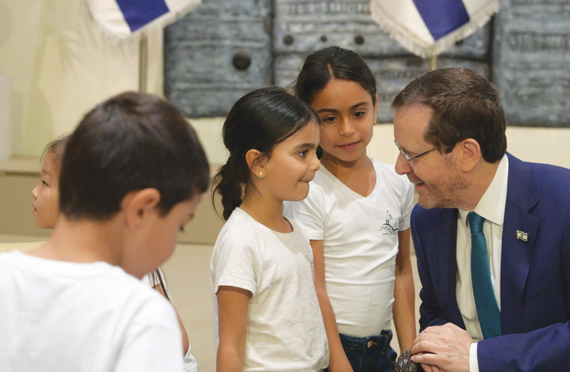  PRESIDENT ISAAC HERZOG with some of his junior guests from the TALI school (photo credit: AMOS BEN GERSHOM/GPO)