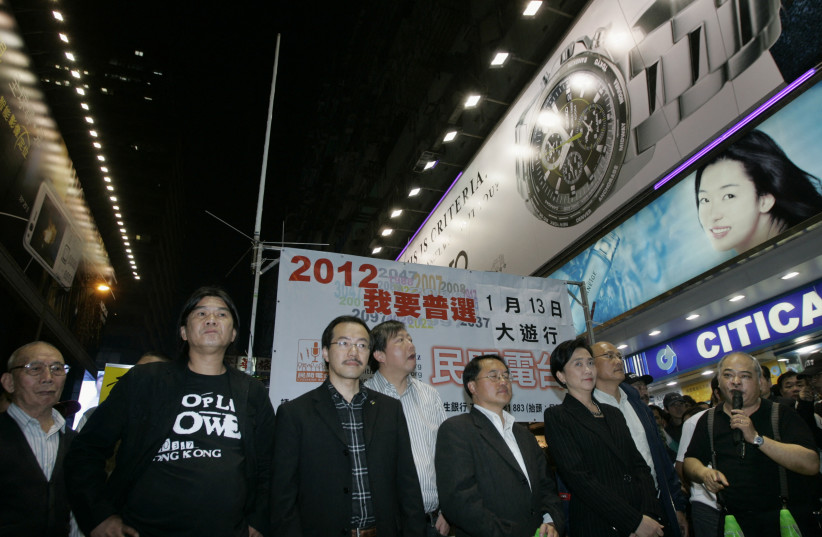  An antenna is set up on a street in Hong Kong's Mongkok shopping district as pro-democracy activists Leung Kwok-hung (2nd L) and Tsang Kin-shing (R), a host at Citizens' Radio, along with pro-democracy lawmakers Emily Lau (3rd R) and Lee Wing-tat (4th R), take part in a broadcast despite a governme (photo credit: REUTERS/Bobby Yip/File Photo)