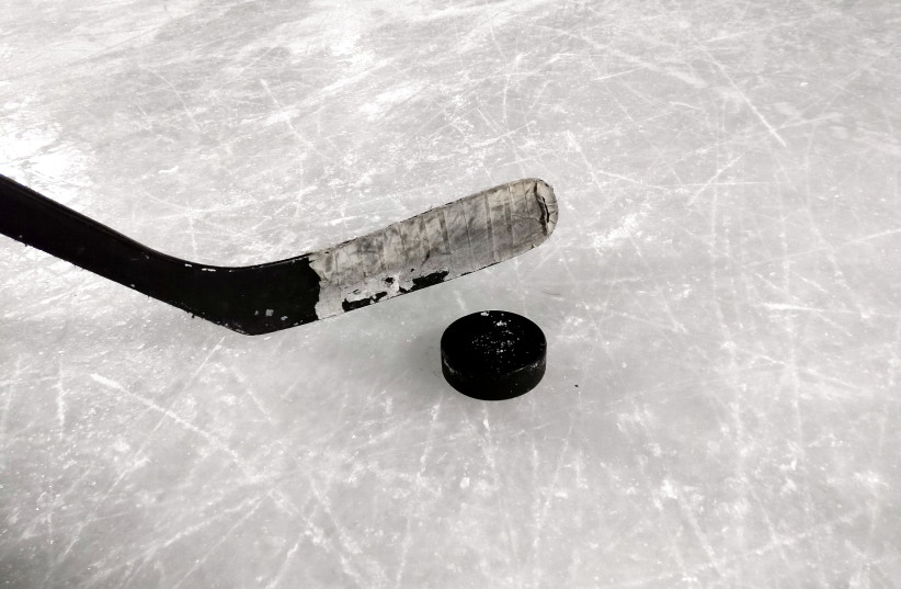  Hockey stick and puck on ice (photo credit: Wikimedia Commons)