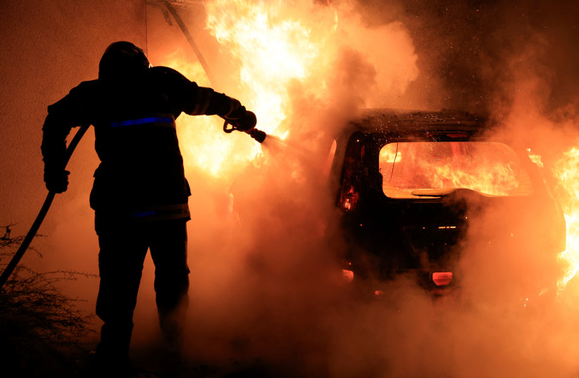  A French firefighter works to extinguish a burning car during the fifth day of protests following the death of Nahel, a 17-year-old teenager killed by a French police officer in Nanterre during a traffic stop, in Tourcoing, France, July 2, 2023. (photo credit: PASCAL ROSSIGNOL/REUTERS)