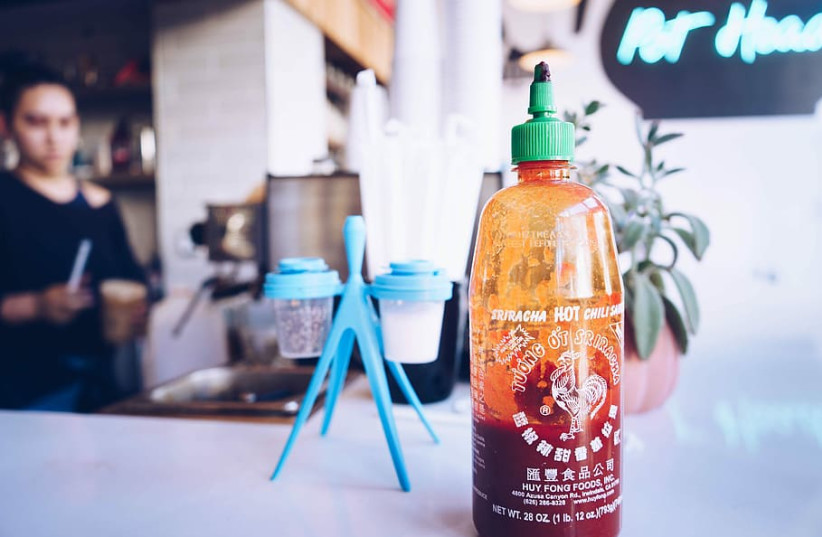  Sriracha bottle on a restaurant table (photo credit: WALLPAPER FLARE)