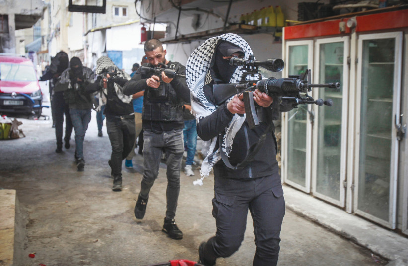  FATAH GUNMEN hold their weapons during a parade in the Balata camp, in Nablus, in May. The PA is losing the capacity to control the territory as Fatah operatives participate in battles against the IDF. (photo credit: NASSER ISHTAYEH/FLASH90)