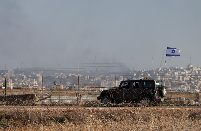 An Israeli military jeep patrols the border between Israel and the West Bank as smoke rises from Israel's side during a raid on Jenin refugee camp in the West Bank, Salem checkpoint July 3, 2023 (photo credit: REUTERS/Ronen Zvulun)
