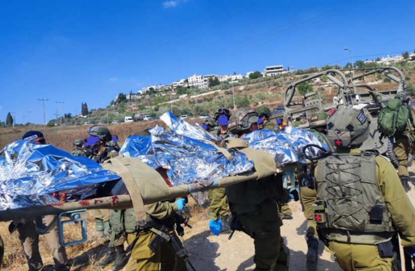  IDF soldiers are seen at the scene of the shooting attack in Kedumin, July 6, 2023 (photo credit: CHAIM ATIAS)