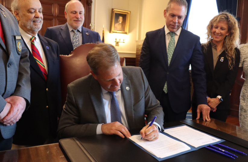  NH Gov. Christopher Sununu signed an executive order today against the anti-Israel BDS movement. Looking on to his immediate right is Israel’s Permanent Representative to the United Nations, Ambassador Gilad Erdan. (photo credit: IAC FOR ACTION)