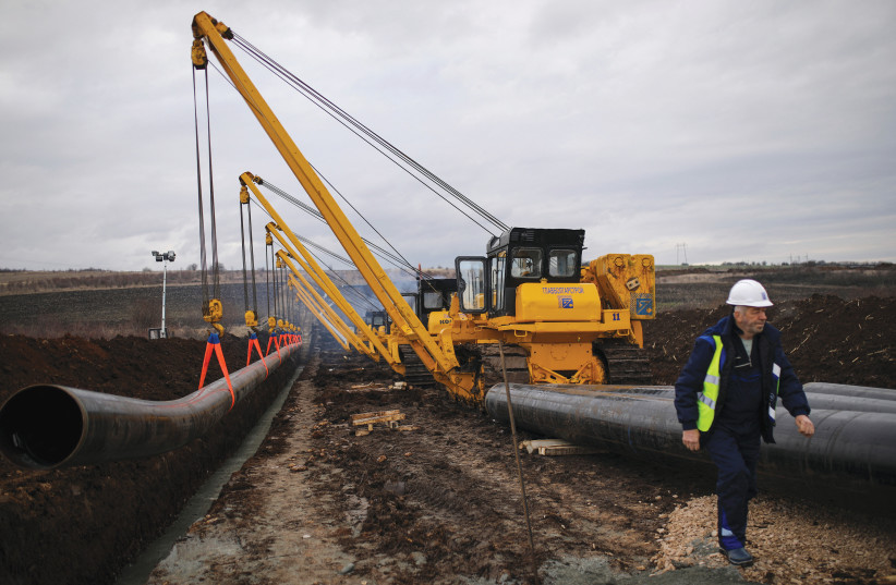  A WORKER walks next to a pipe at the launch of the construction of an interconnector gas pipeline to link the gas networks of Bulgaria and Serbia, near Golyanovtsi, Bulgaria, February 1, 2023. Start investing. Keep it simple: Stick to stocks, bonds, and real estate, says the writer.  (photo credit: STOYAN NENOV/REUTERS)