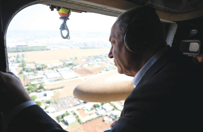  RIME MINISTER Benjamin Netanyahu takes a look at the terrain below as he travels by helicopter to the Salem Crossing near Jenin during this week’s IDF operation. (photo credit: HAIM ZACH/GPO)