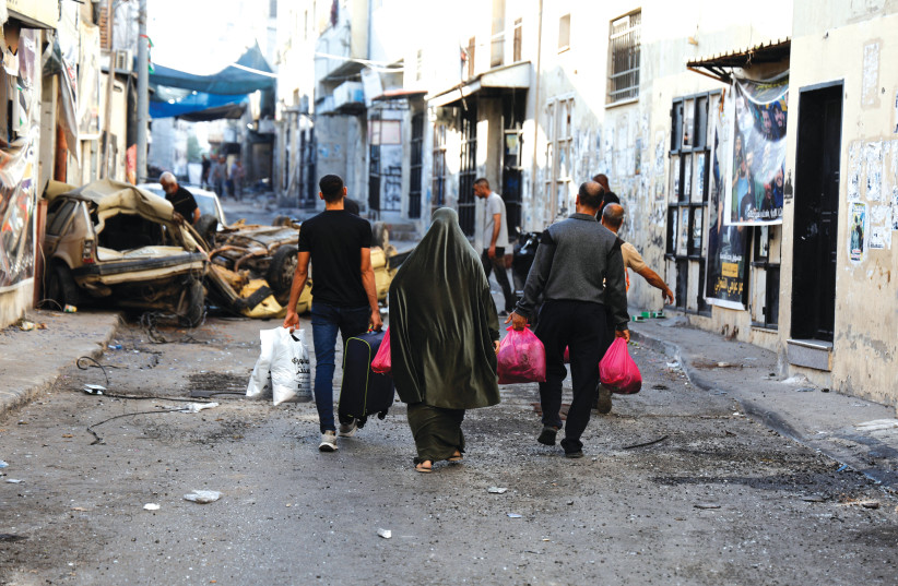  RESIDENT CARRY belongings in the Jenin refugee camp after the IDF’s withdrawal on Wednesday. (photo credit: AMMAR AWAD/REUTERS)