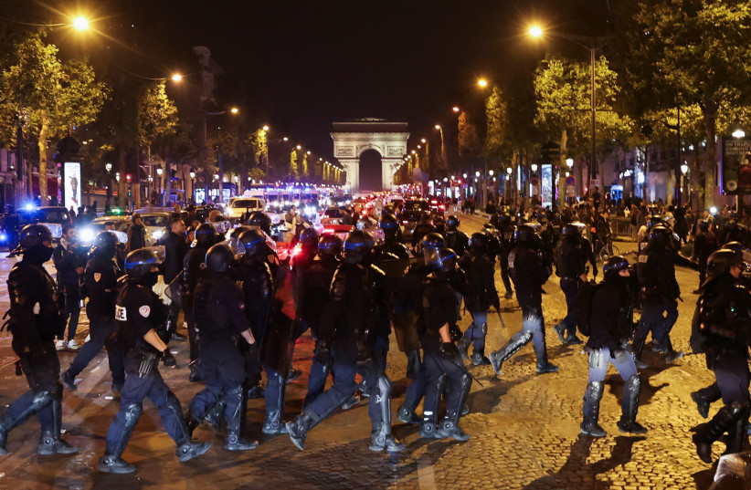  Police officers take position during riots following the death of Nahel, a 17-year-old teenager killed by a French police officer in Nanterre during a traffic stop, at Champs Elysees in Paris, France, July 1, 2023 (photo credit: REUTERS/NACHO DOCE)