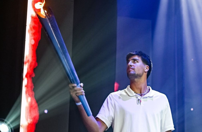  ISRAELI NBA player Deni Avdija lights the torch at the opening of the JCC Maccabi Games in Israel on Sunday night (photo credit: CHEN OFIR/COURTESY)