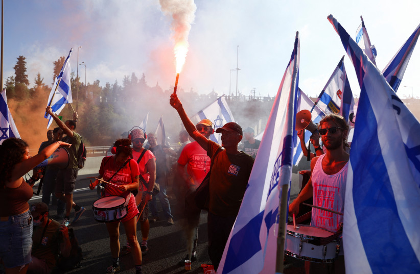  People block a highway to Jerusalem to demonstrate on 'Day of Paralysis' in protest against Israeli Prime Minister Benjamin Netanyahu and his nationalist coalition government's judicial overhaul, July 11, 2023.  (photo credit: REUTERS/Ronen Zvulun)
