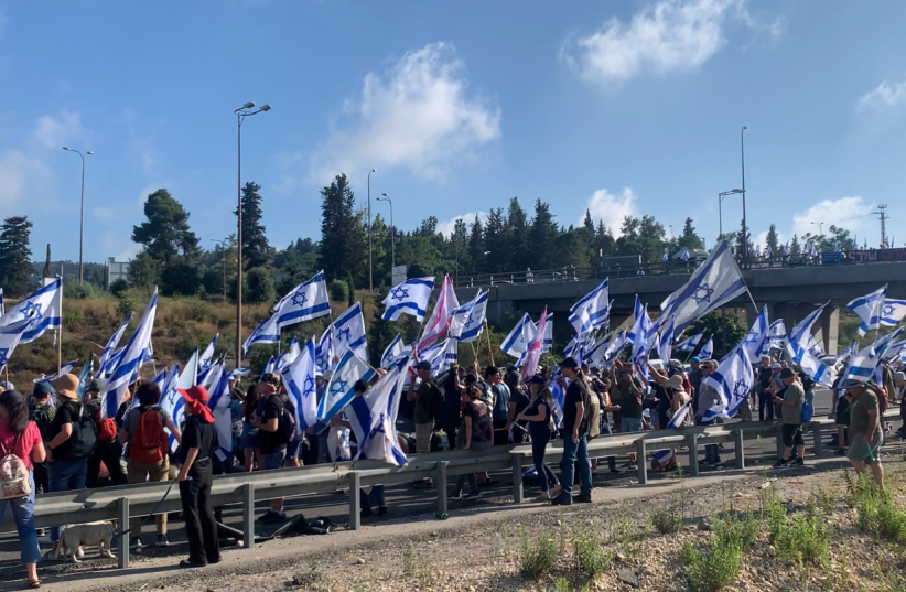  Masses gather at Hemed Interchange to protest the preliminary passage of the Reasonableness Standard in the Knesset the night before. (photo credit: ARIEL SHEINBERG)