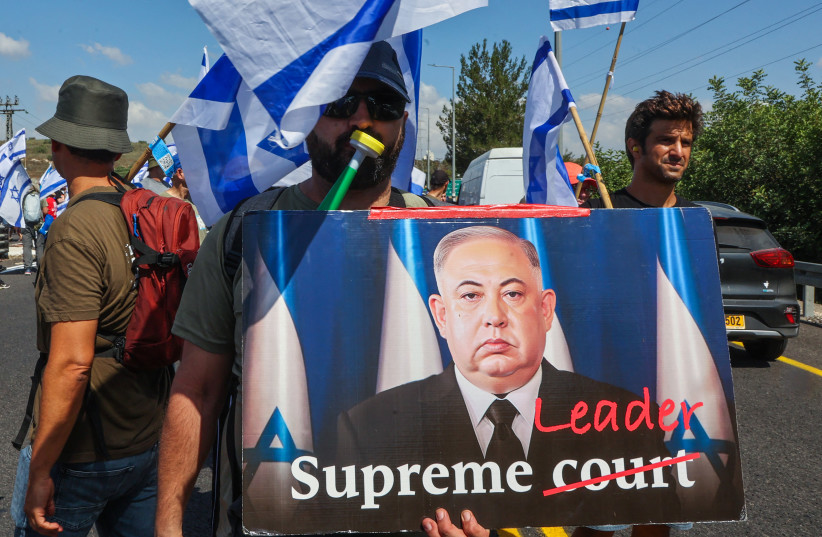  A protester holds a banner depicting Prime Minister Benjamin Netanyahu as North Korea's Kim Jong Un, Tel Aviv, July 11, 2023. (photo credit: GIL COHEN-MAGEN/AFP VIA GETTY IMAGES)