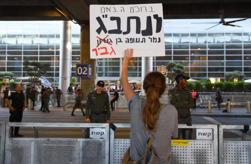  Demonstrator holding up a sign at Ben Gurion Airport (photo credit: I.H. Mintz)