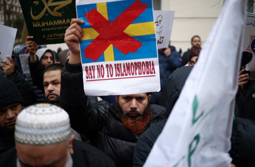  A man displays a placard during a protest following the burning of the Koran in Stockholm, outside the embassy of Sweden in London, Britain, January 28, 2023.  (photo credit: REUTERS/HENRY NICHOLLS)