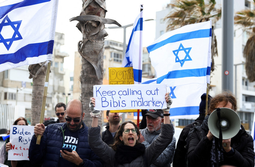  Demonstrators show their support for US President Joe Biden, for not inviting Israeli Prime Minister Benjamin Netanyahu to the White House, in front of the US Consulate in Tel Aviv, Israel, March 30, 2023. (photo credit: RONEN ZVULUN/REUTERS)