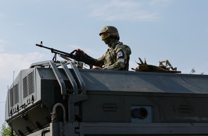  A Russian service member holds a weapon on the top of a military vehicle in the course of Ukraine-Russia conflict in the Russian-controlled city of Enerhodar in the Zaporizhzhia region, Ukraine September 1, 2022. (photo credit: Alexander Ermochenko/Reuters)