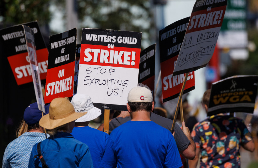  Striking Writers Guild of America (WGA) members walk the picket line in front of Netflix offices in Los Angeles, California, US, July 12, 2023.  (photo credit: REUTERS/MIKE BLAKE)
