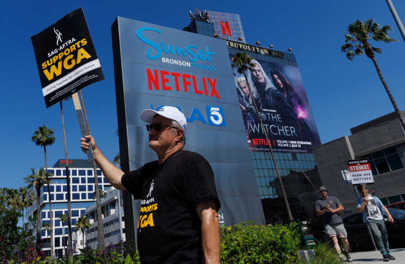  Striking Writers Guild of America (WGA) members walk the picket line in front of Netflix offices in Los Angeles, California, US, July 12, 2023.  (photo credit: REUTERS/MIKE BLAKE)