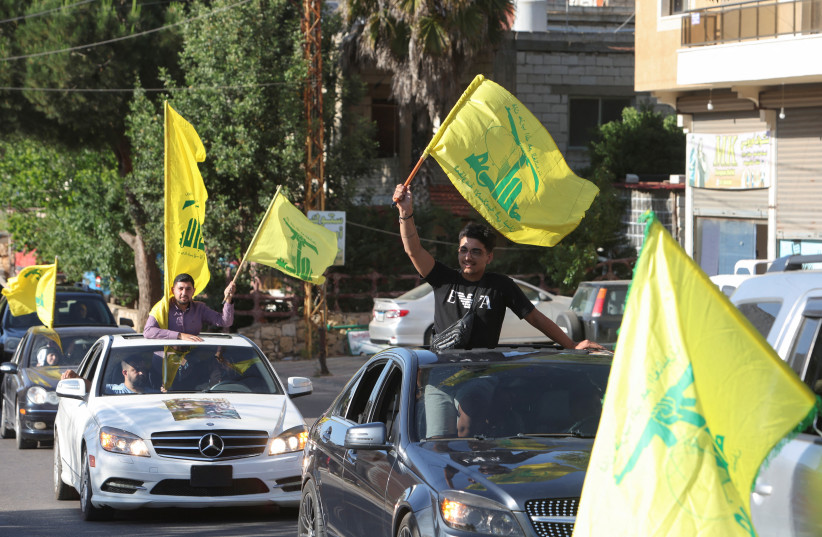  Supporters of Lebanon's Hezbollah leader Sayyed Hassan Nasrallah, carry flags as they ride in a convoy, marking the commemoration of Israel's withdrawal from southern Lebanon in 2000, in Houla village, near the border with Israel, southern Lebanon, May 25, 2023 (photo credit: REUTERS/AZIZ TAHER)