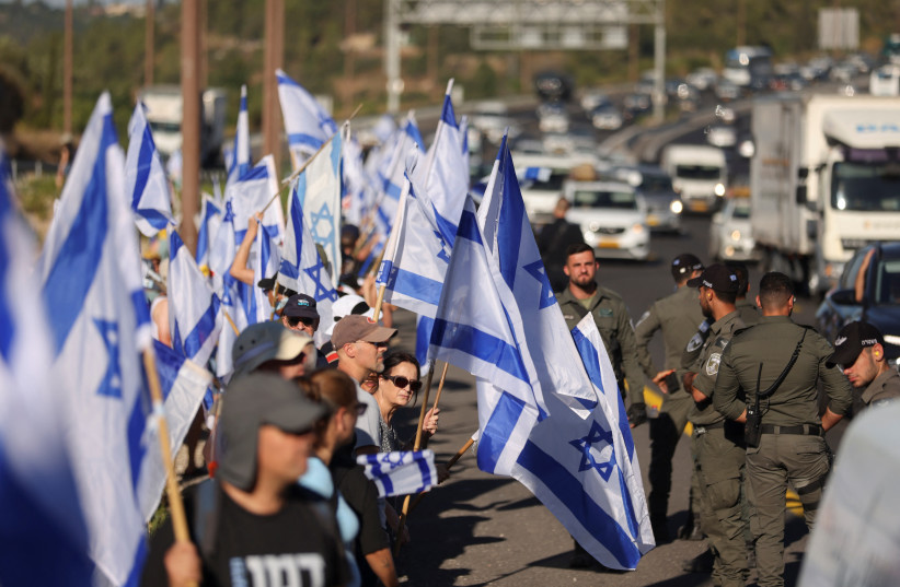  People demonstrate on the 'Day of National Resistance' in protest against Israeli Prime Minister Benjamin Netanyahu and his nationalist coalition government's judicial reform, on a highway leading to Jerusalem July 18, 2023.  (photo credit: RONEN ZVULUN/REUTERS)