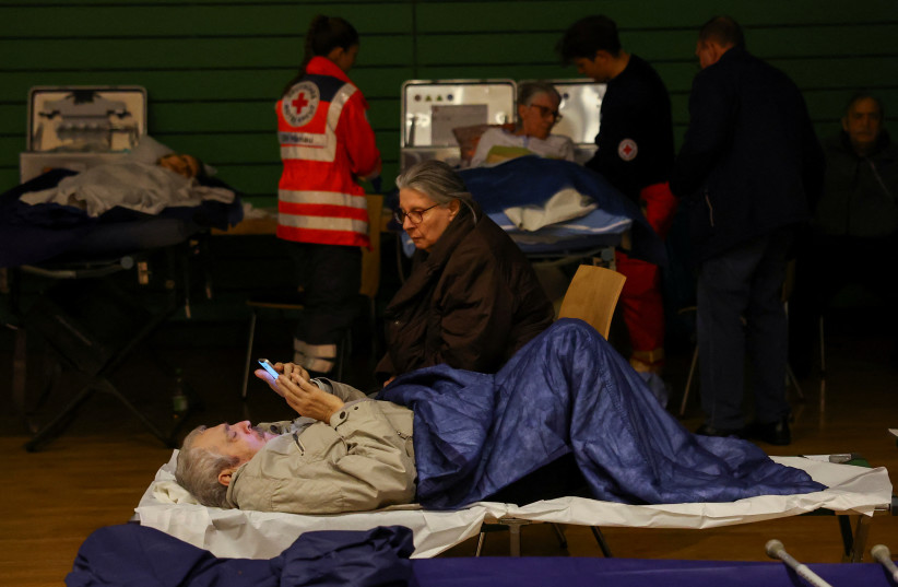 People rest in a shelter during evacuation before the detonation of a World War II bomb that was found on the factory site of German industrial giant Heraeus in Hanau, Germany, March 1, 2023. (photo credit: KAI PFAFFENBACH/REUTERS)