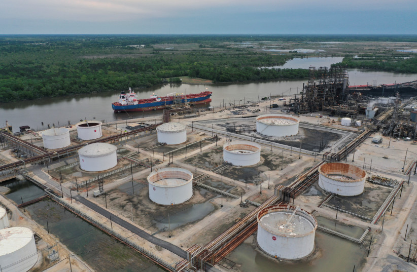An aerial view of an oil tanker and storage tanks at Exxon Mobil’s Beaumont oil refinery, which produces and packages Mobil 1 synthetic motor oil, in Beaumont, Texas, US, March 18, 2023 (photo credit: BING GUAN/REUTERS)