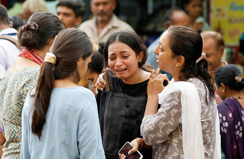 Women react upon seeing the body of their relative at a hospital, after a road accident in Ahmedabad, India, July 20, 2023. (photo credit: REUTERS/AMIT DAVE)
