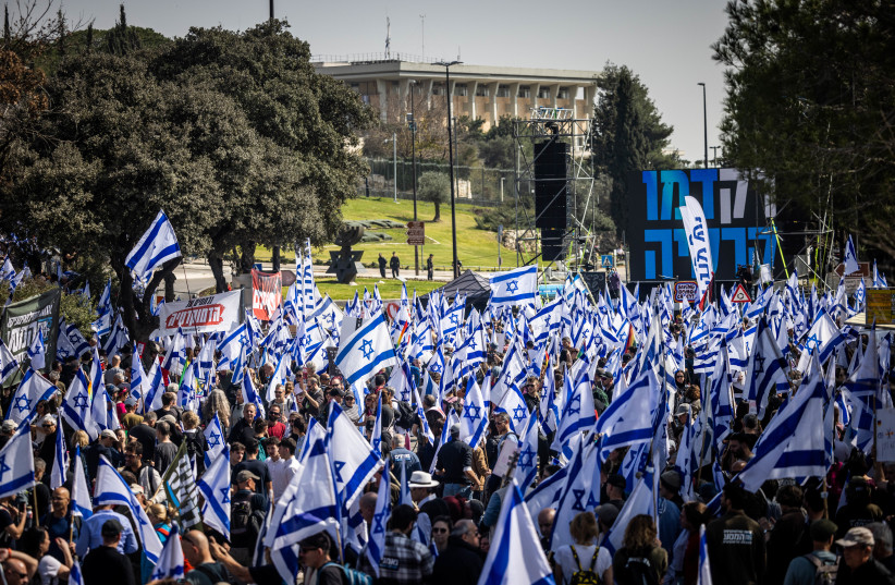 Thousands wave the Israeli flag as they protest against the judicial overhaul at the Knesset in Jerusalem. February 20, 2023. (photo credit: YONATAN SINDEL/FLASH90)