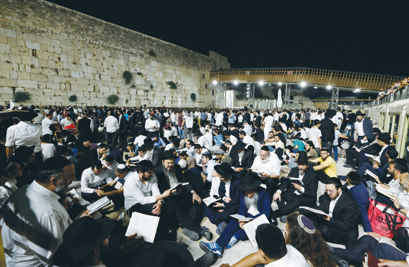 WORSHIPERS SIT on the ground as a sign of mourning on Tisha Be’av last year at the Western Wall (photo credit: OLIVIER FITOUSSI/FLASH90)