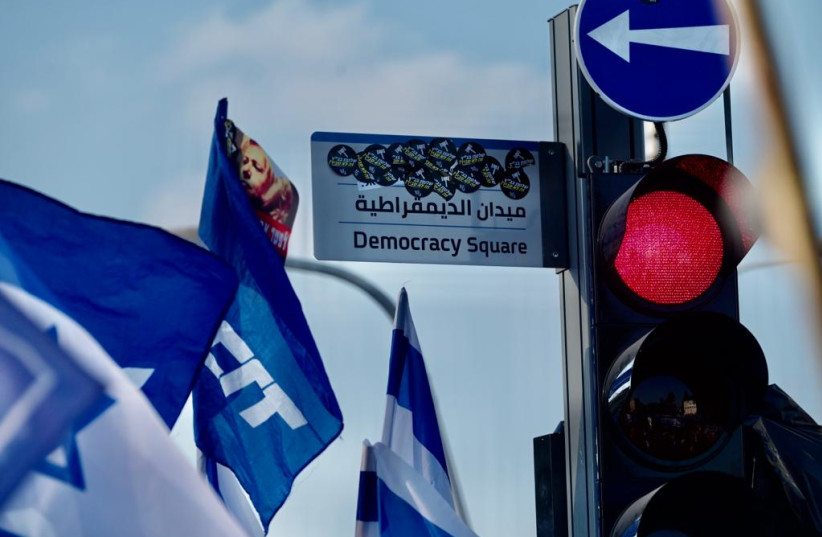  Pro-judicial reform protesters cover up the "Democracy Square" sign in Tel Aviv. July 23, 2023 (photo credit: AVSHALOM SASSONI)
