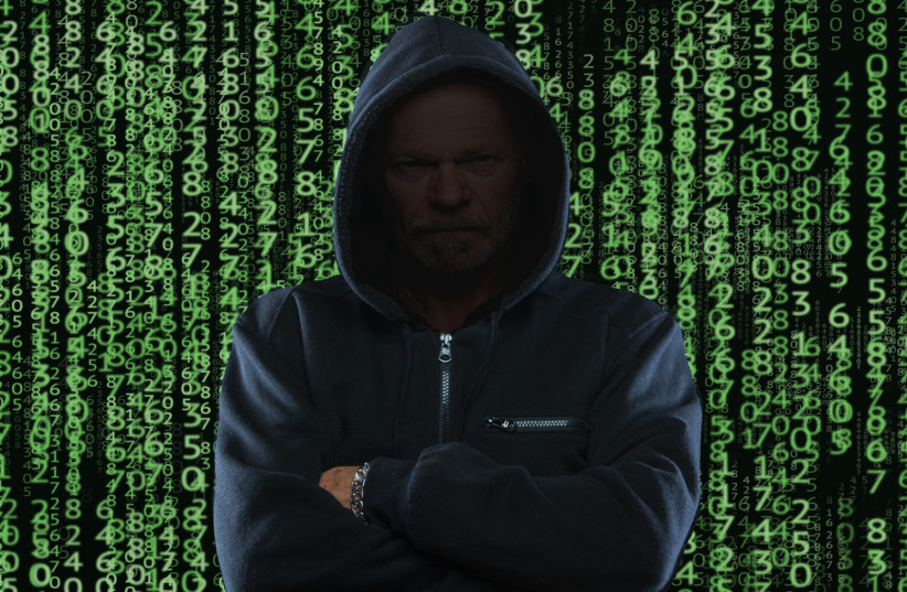  Hacker standing with digital green numbers behind him. (photo credit: WALLPAPER FLARE)