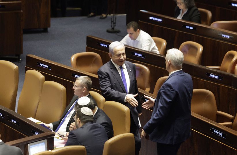  Israeli Prime Minister Benjamin Netanyahu and National Unity leader MK Benny Gantz are seen moving to shake hands in the Knesset amid the vote on the controversial reasonableness standard bill, in Jerusalem, on Monday, July 24, 2023. (photo credit: MARC ISRAEL SELLEM/THE JERUSALEM POST)
