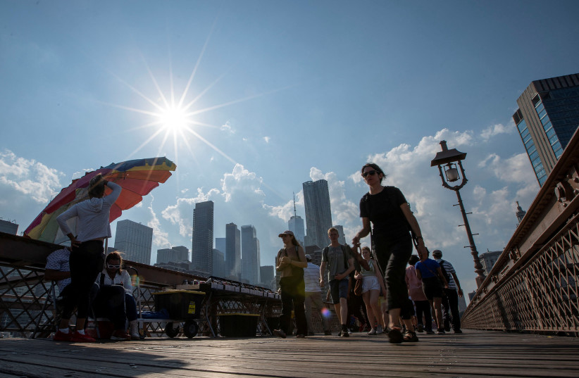  People visit the Brooklyn Bridge during hot weather in New York City, US, July 13, 2023.  (photo credit: EDUARDO MUNOZ / REUTERS)