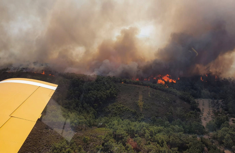  A Turkish firefighting plane flies over a wildfire burning on the island of Rhodes, Greece, July 24, 2023. (photo credit: Turkish Ministry of Agriculture and Forestry/Handout via REUTERS)