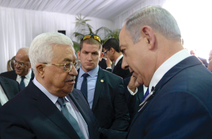  Palestinian Authority President Mahmoud Abbas shakes hands with Prime Minister Benjamin Netanyahu at the funeral of Shimon Peres in Jerusalem, September 30, 2016.  (photo credit: AMOS BEN GERSHOM/GPO)