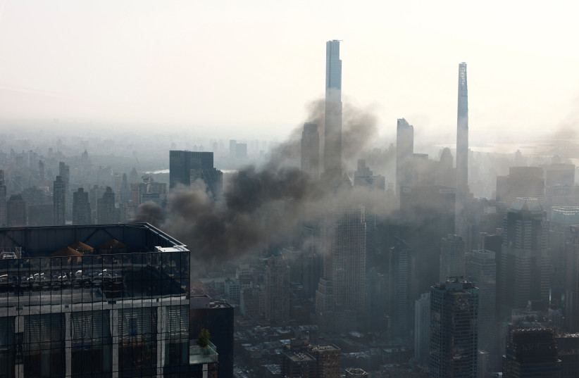 Smoke is visible after a construction crane caught fire on a high-rise building in Manhattan, New York City, U.S., July 26, 2023 (photo credit: Amr Alfiky/Reuters)