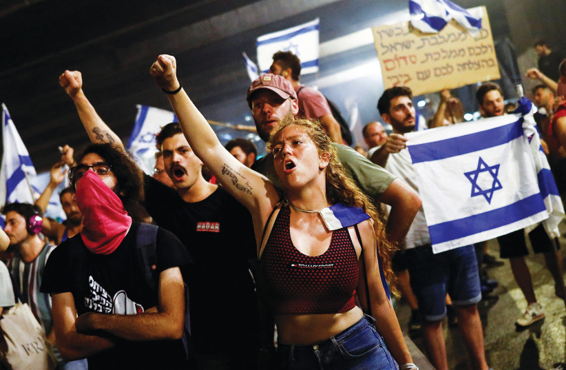 PROTESTERS BLOCK the Ayalon Highway in Tel Aviv Monday night during a demonstration following the Knesset vote on the contested bill that limits Supreme Court powers to void some government decisions. (photo credit: CORINNA KERN/REUTERS)