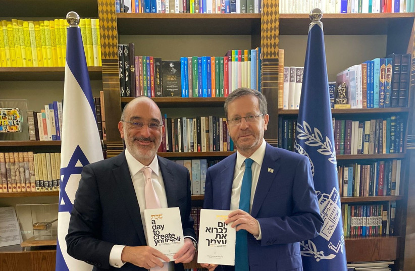  Chief Rabbi Dr. Warren Goldstein and President Isaac Herzog holding his newest book. (photo credit: JASON CROUSE)