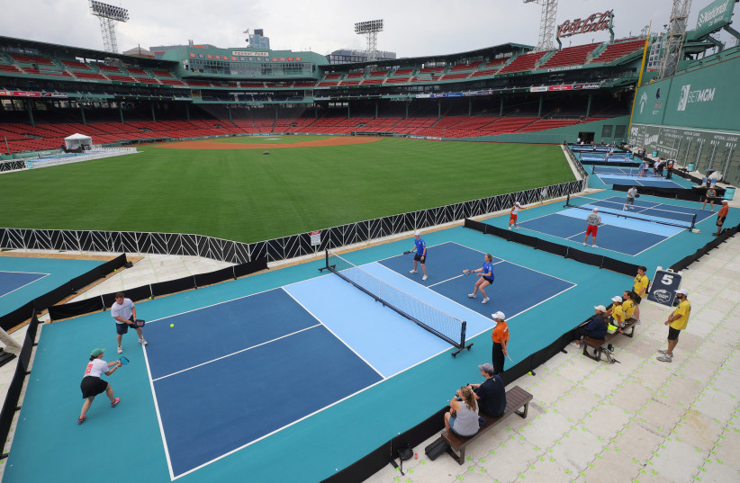 Competitors play pickleball on courts set up in the outfield of Fenway Park, home of Major League Baseball’s Boston Red Sox, during the 2023 Ballpark Series in Boston, Massachusetts, U.S., July 14, 2023. (photo credit: REUTERS/BRIAN SNYDER)