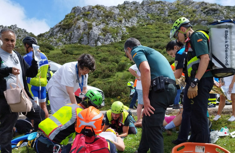 Emergency services members attend to an injured person after a tourist bus carrying 48 people, including children, crashed on a road in Cangas de Onis, in the northern region of Asturias, Spain, July 31, 2023. (photo credit: Guardia Civil/Handout via REUTERS)