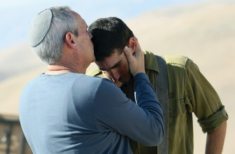  A FATHER kisses his son after the soldier completed a military drill. (photo credit: MOSHE SHAI/FLASH90)