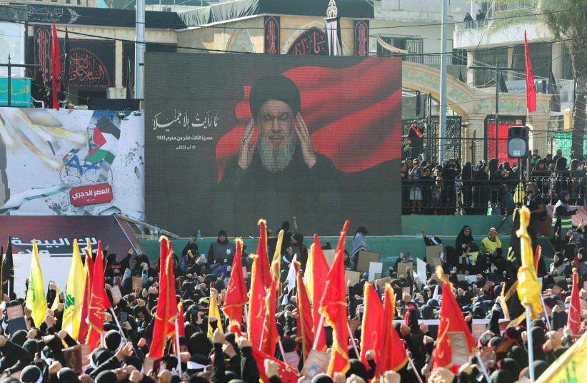  Supporters of Lebanon's Hezbollah leader Sayyed Hassan Nasrallah listen to him as he addresses them through a screen during a rally marking Muharram, a period of mourning for Shi'ite Muslims around the world, in Nabatiyeh, southern Lebanon August 1, 2023. (photo credit: AZIZ TAHER/REUTERS)