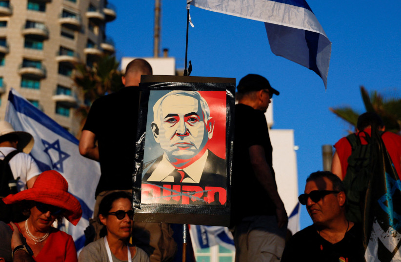  A placard depicting Israeli Prime Minister Benjamin Netanyahu is seen as people demonstrate on the 'Day of National Resistance' in protest against him and his nationalist coalition government's judicial overhaul, near U.S. Consulate in Tel Aviv, Israel July 18, 2023 (photo credit: REUTERS/AMMAR AWAD)