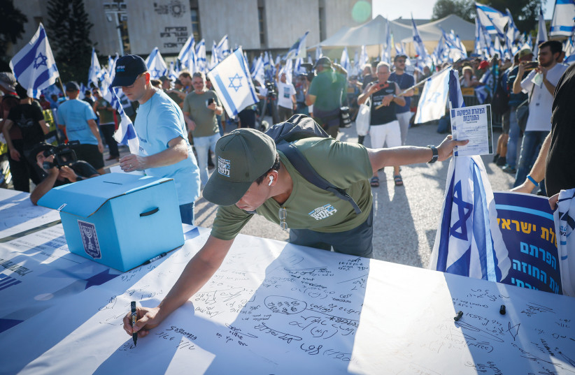  RESERVE SOLDIERS sign a statement saying they will not continue to do military service, as part of a protest against the government’s judicial reform, in Tel Aviv, last month. (photo credit: CHAIM GOLDBEG/FLASH90)